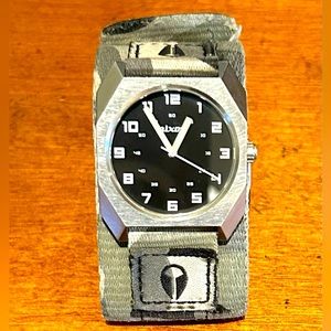 Nixon the Scout watch with camouflage band and black watch face.